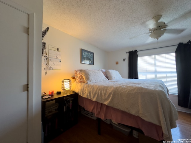 bedroom featuring ceiling fan, a textured ceiling, and dark hardwood / wood-style flooring