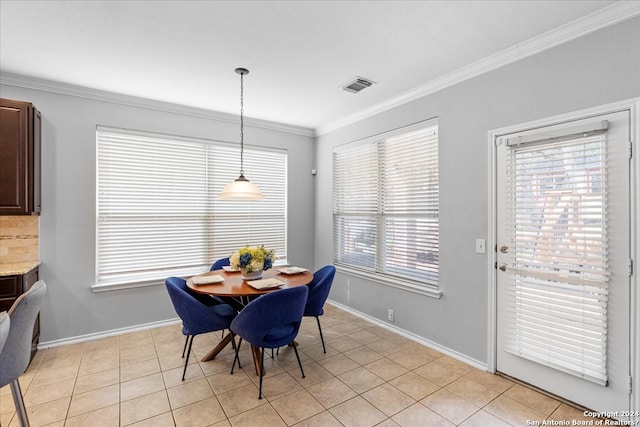 dining room with crown molding and light tile floors