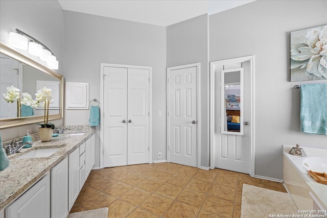 bathroom with double sink vanity, tile floors, and a tub