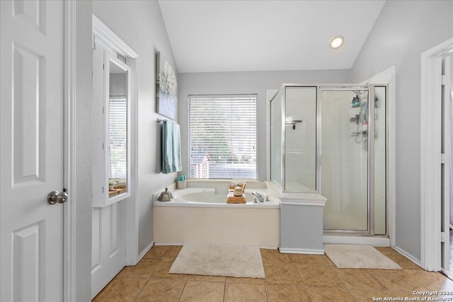 bathroom with lofted ceiling, separate shower and tub, and tile floors