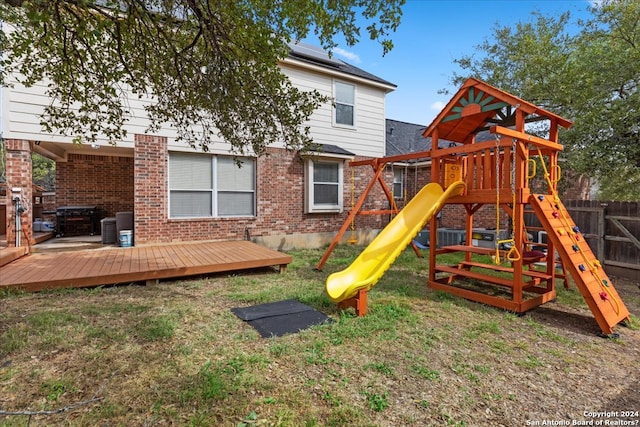 view of jungle gym featuring central AC unit and a wooden deck