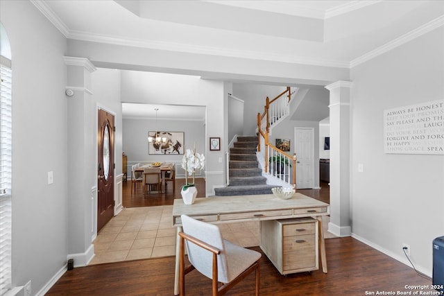 kitchen with light brown cabinets, ornate columns, kitchen peninsula, a notable chandelier, and dark tile flooring