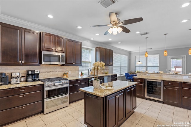 kitchen with appliances with stainless steel finishes, pendant lighting, ceiling fan, light tile floors, and beverage cooler