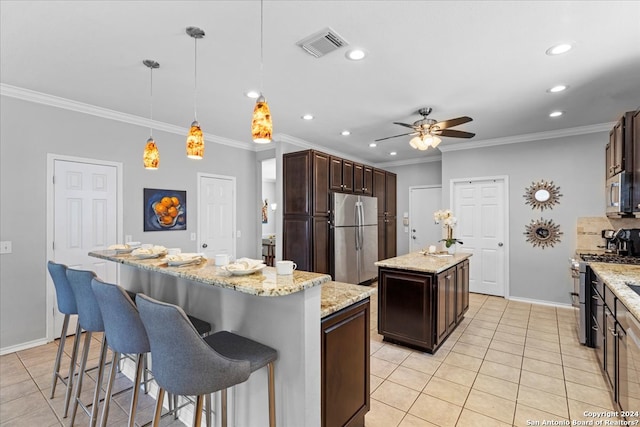 kitchen featuring stainless steel appliances, a kitchen island with sink, pendant lighting, ceiling fan, and light tile flooring