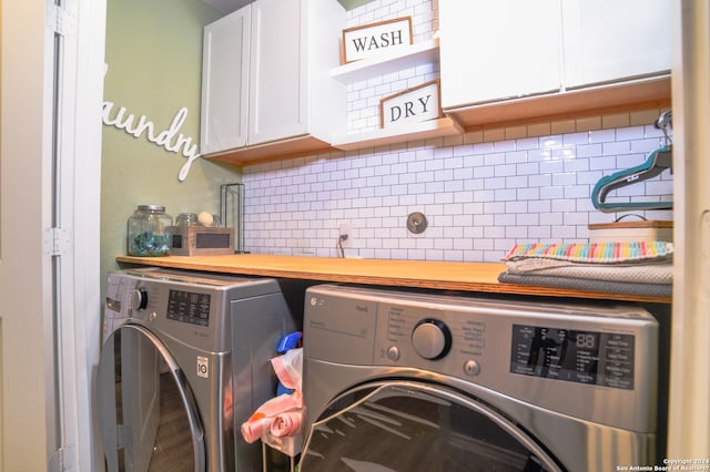 laundry room with washing machine and clothes dryer and cabinets