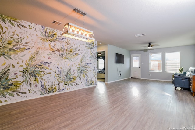 interior space with ceiling fan with notable chandelier and dark hardwood / wood-style flooring