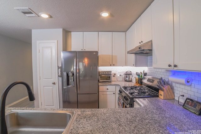 kitchen featuring sink, white cabinets, dark stone countertops, backsplash, and stainless steel appliances