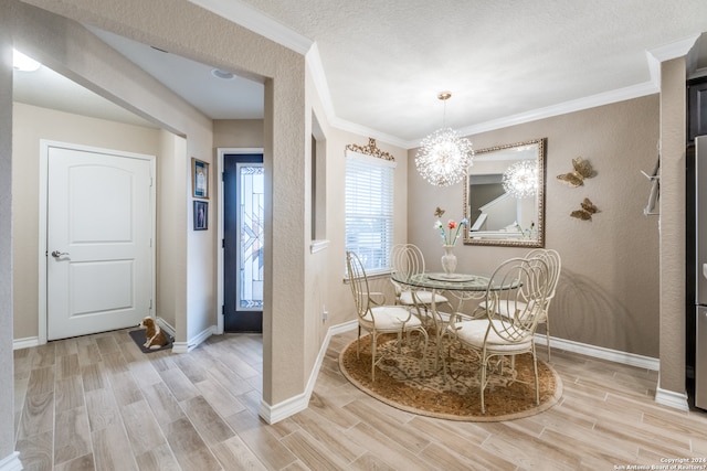 dining room with an inviting chandelier, ornamental molding, a textured ceiling, and light hardwood / wood-style flooring