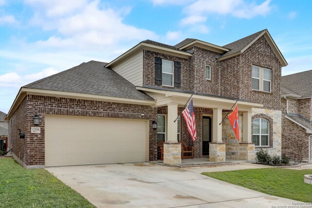 view of front of house featuring a front yard, covered porch, and a garage