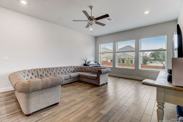 living room with light hardwood / wood-style flooring and ceiling fan