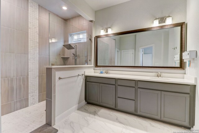 bathroom with dual bowl vanity, tile flooring, and tiled shower