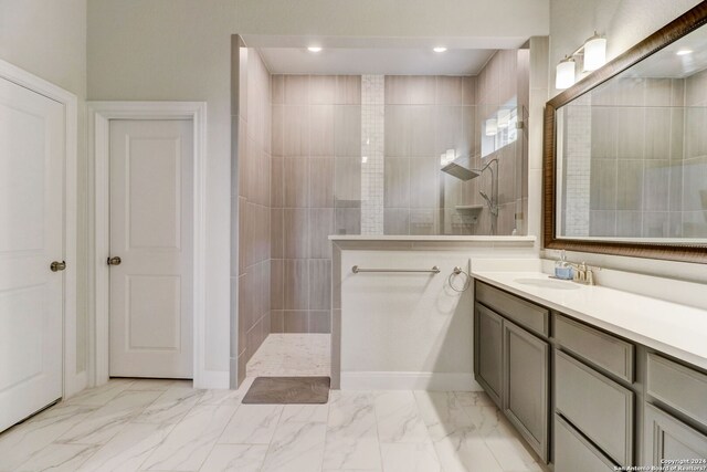 bathroom with tiled shower, tile floors, and large vanity