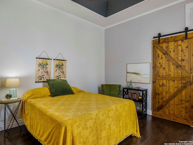 bedroom featuring a barn door, crown molding, baseboards, and wood finished floors