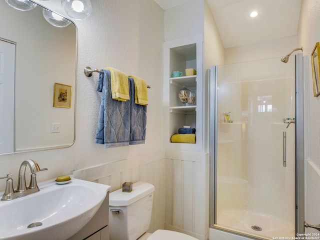 bathroom featuring toilet, a wainscoted wall, vanity, a shower stall, and built in shelves