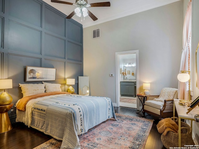 bedroom featuring ceiling fan, crown molding, dark wood-type flooring, and ensuite bath