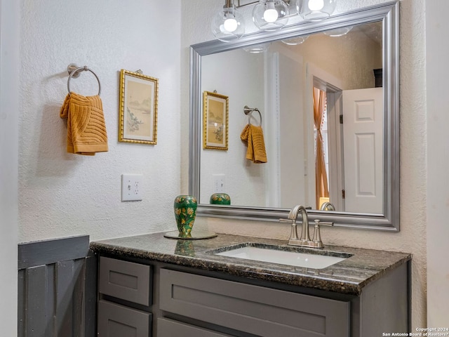 bathroom with a textured wall and vanity