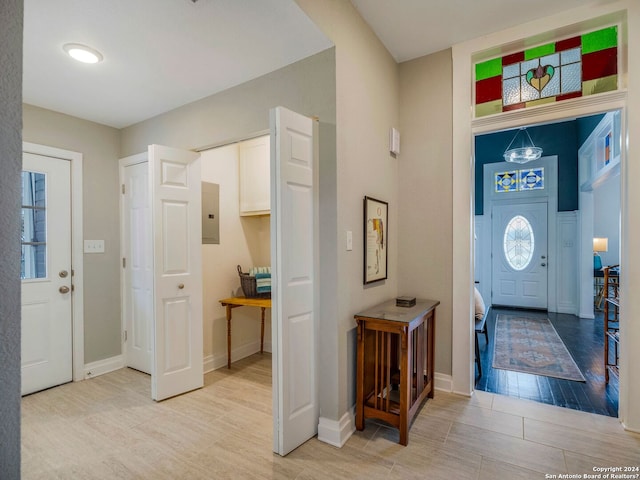 entrance foyer with wood finish floors, electric panel, and baseboards