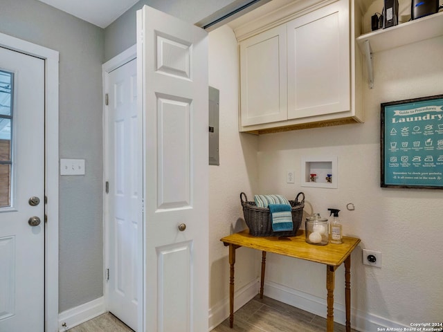 interior space with cabinet space, baseboards, hookup for a washing machine, light wood-type flooring, and electric dryer hookup