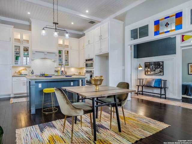 kitchen featuring a sink, white cabinetry, beam ceiling, tasteful backsplash, and dark wood finished floors