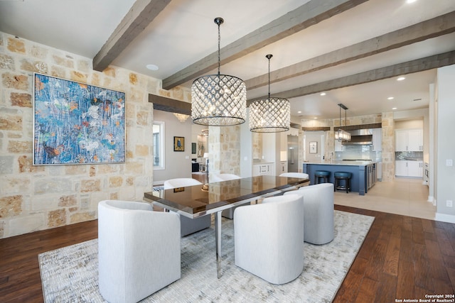 dining space featuring beamed ceiling and light wood-type flooring