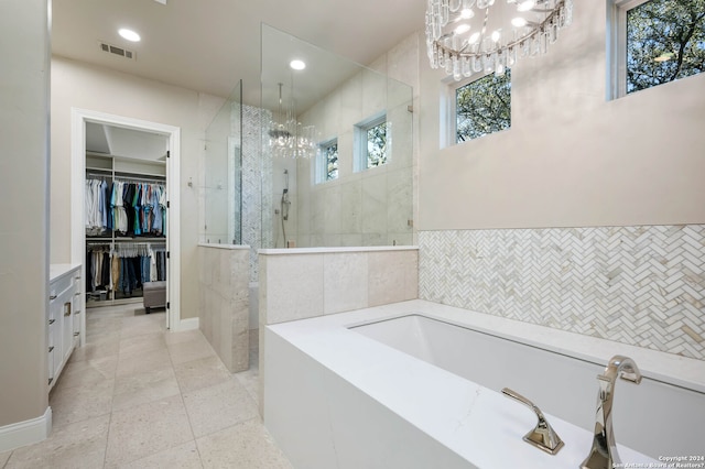 bathroom featuring vanity, tile walls, a chandelier, independent shower and bath, and tile patterned flooring