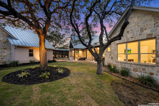 yard at dusk featuring a patio area