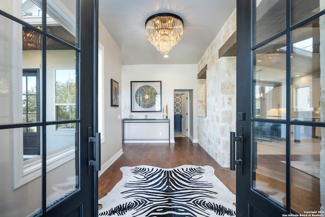 hallway featuring a notable chandelier and dark hardwood / wood-style flooring