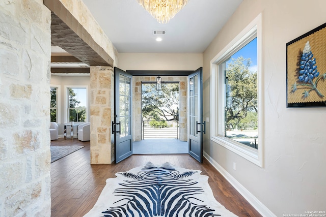 foyer entrance featuring a notable chandelier, beamed ceiling, and dark hardwood / wood-style floors