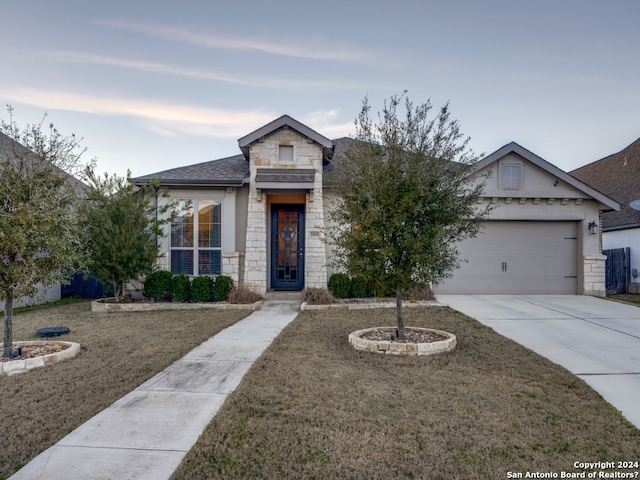 view of front of property with a garage and a front lawn