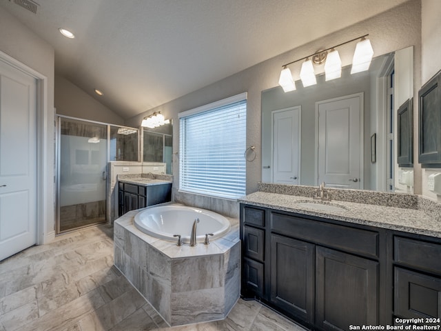 bathroom with vanity with extensive cabinet space, lofted ceiling, separate shower and tub, tile floors, and dual sinks