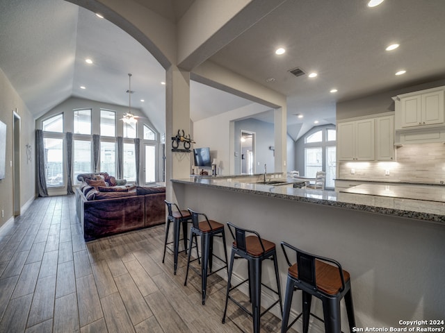 kitchen featuring ceiling fan, stone counters, dark wood-type flooring, and white cabinetry