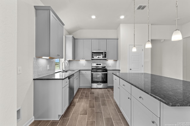 kitchen with gray cabinets, hanging light fixtures, and stainless steel appliances