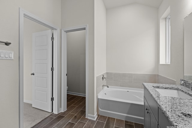 bathroom with vanity, toilet, and a bath