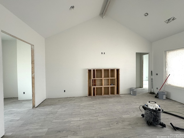 unfurnished room featuring high vaulted ceiling and beam ceiling