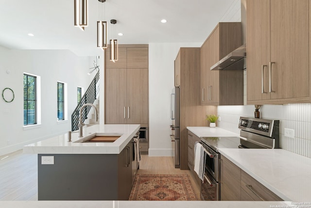 kitchen with stainless steel appliances, backsplash, decorative light fixtures, a kitchen island with sink, and wall chimney exhaust hood