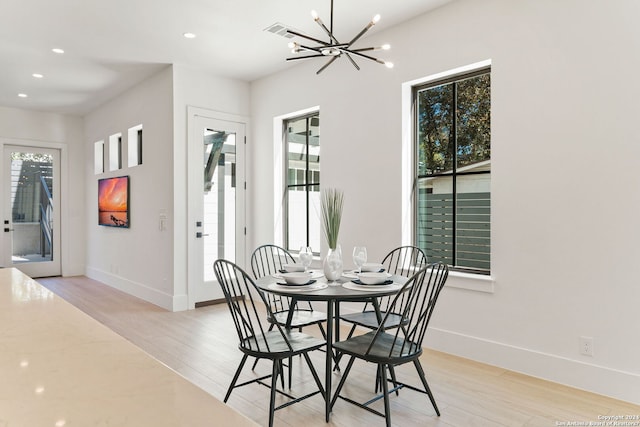 dining space with light wood-type flooring and a chandelier