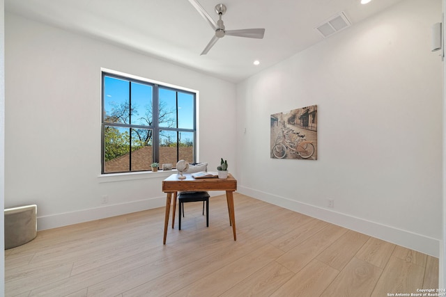 home office with light hardwood / wood-style floors and ceiling fan