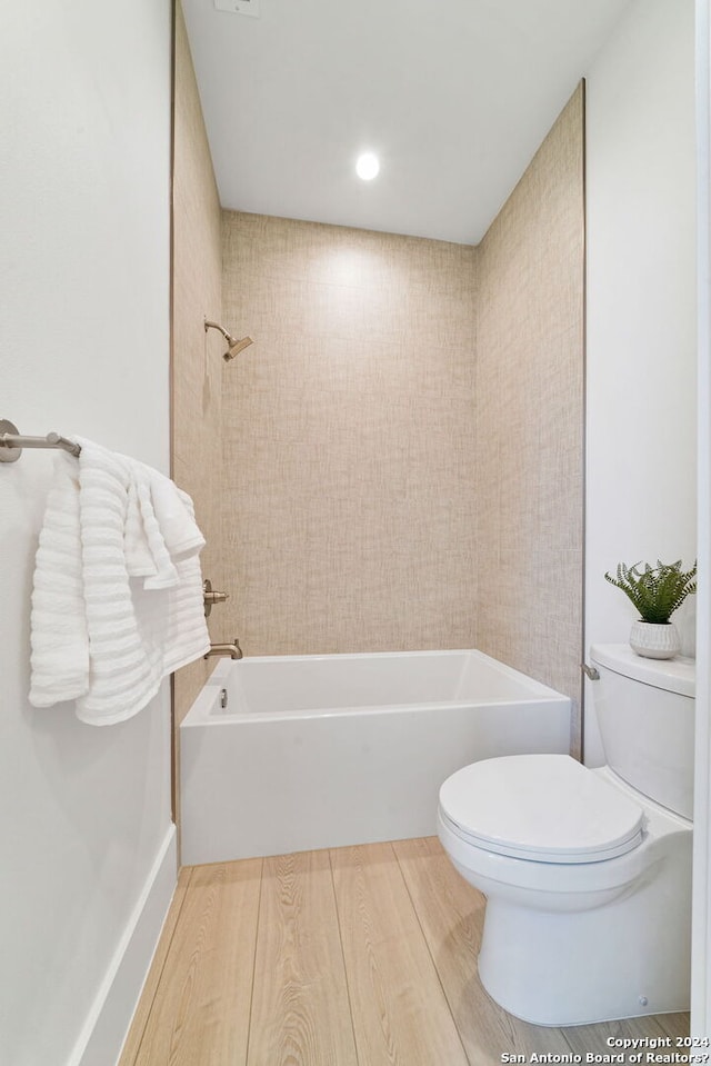 bathroom featuring hardwood / wood-style flooring, shower / tub combination, and toilet