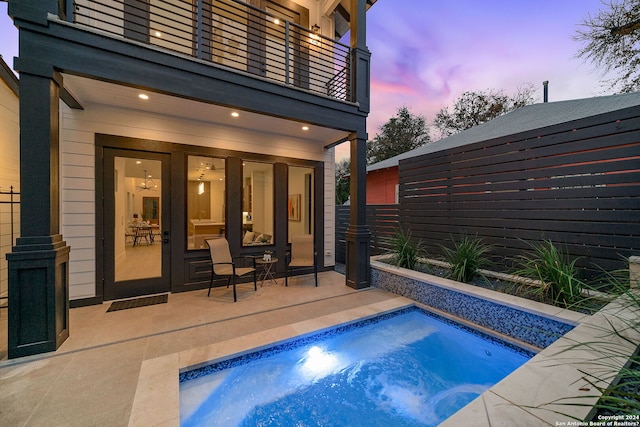 pool at dusk with a patio