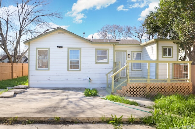 rear view of house featuring a wooden deck