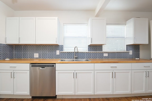 kitchen featuring stainless steel dishwasher, sink, backsplash, and white cabinetry