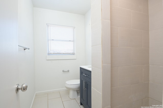 bathroom with toilet, tile flooring, and vanity