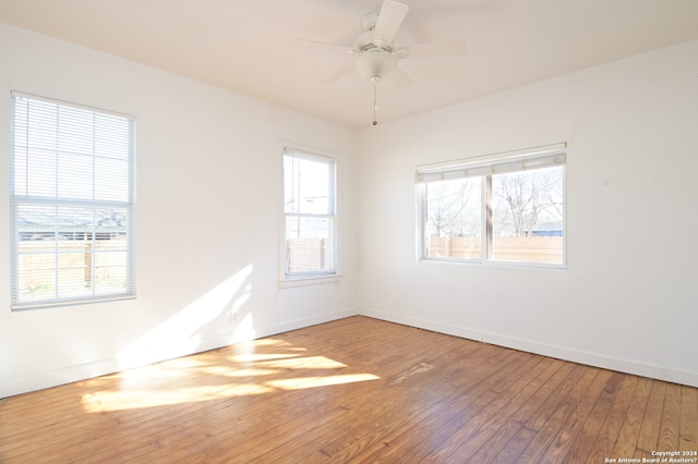 empty room with ceiling fan and hardwood / wood-style flooring