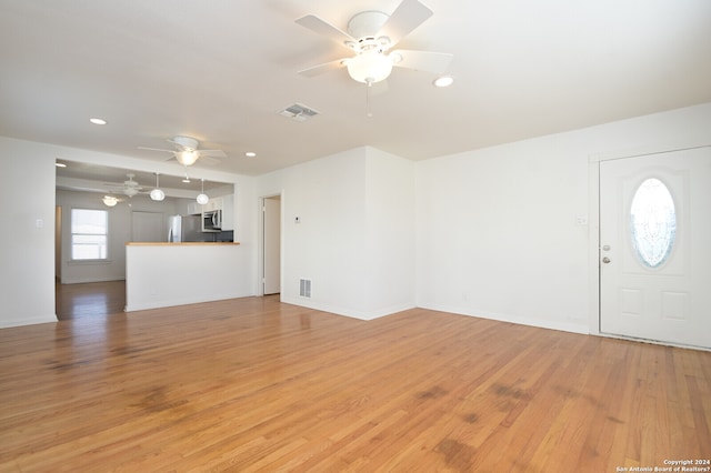 unfurnished living room featuring ceiling fan and wood-type flooring