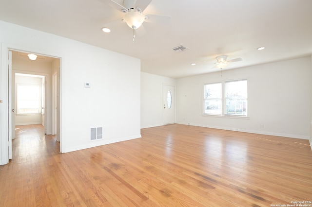 unfurnished room with ceiling fan, a healthy amount of sunlight, and light wood-type flooring