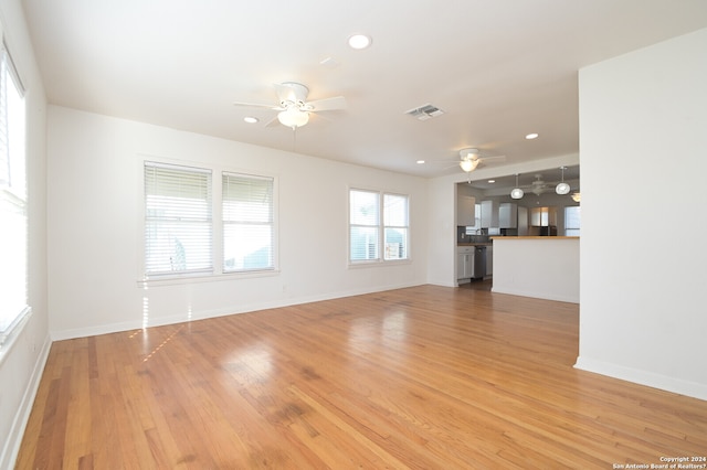 unfurnished living room featuring wood-type flooring and ceiling fan