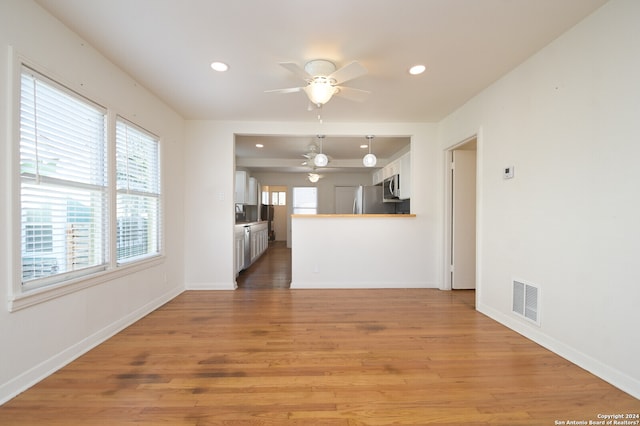 unfurnished living room with ceiling fan and hardwood / wood-style flooring