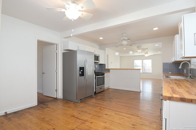 kitchen featuring backsplash, white cabinets, appliances with stainless steel finishes, and sink