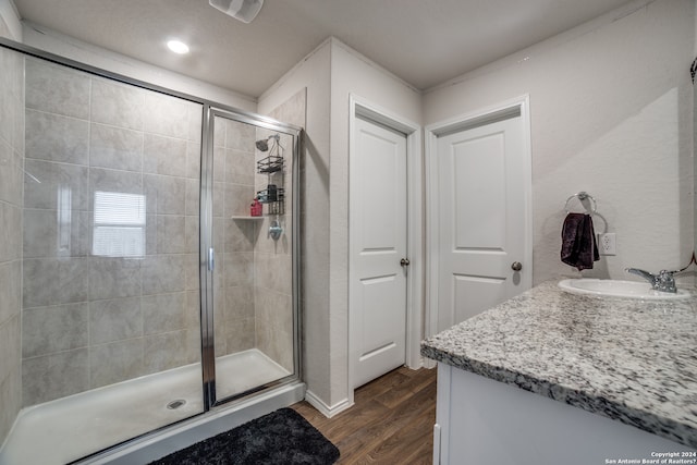 bathroom with an enclosed shower, vanity, and hardwood / wood-style floors