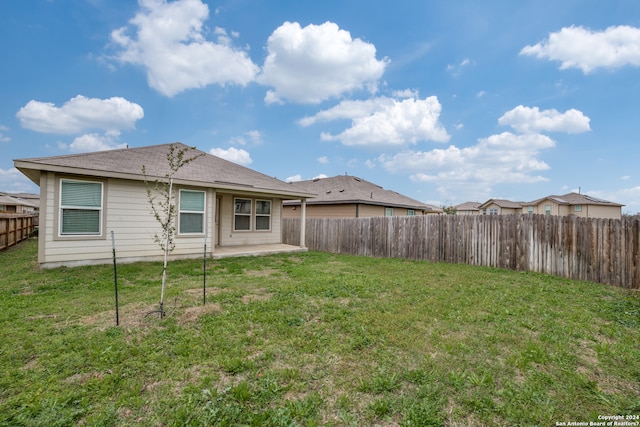 back of property with a yard and a patio